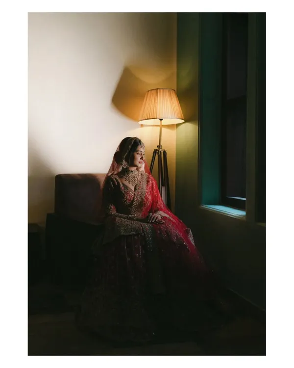 A bride's quiet contemplation in the soft glow of a lamp before her Nikah ceremony. This moody, fine-art portrait captures the soulful anticipation and elegance of the moment, turning a fleeting feeling into a timeless piece of art.
