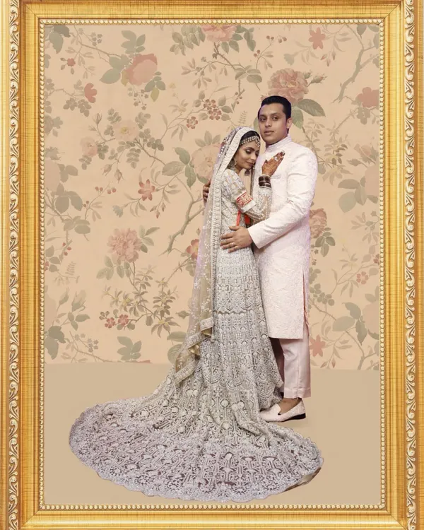 This portrait captures a truly special moment. I designed this intricate silver embroidered lehenga with a long, dramatic trail for the bride, and a coordinated blush pink sherwani for the groom, creating a picture of pure elegance.