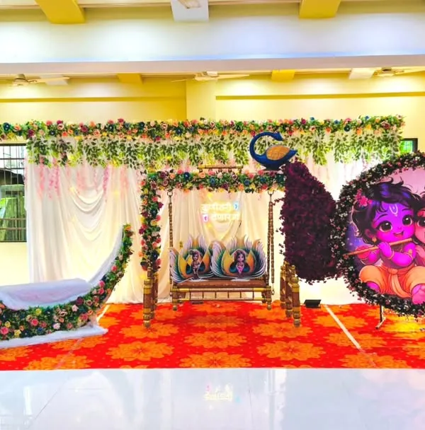 This is one of my most requested Dohale Jevan decoration packages. It features a grand stage with a floral crescent moon seat for the mom-to-be, a traditionally decorated jhula, and beautiful Radha-Krishna graphics, creating a complete and divine setting for your baby shower.