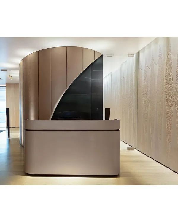 To solve a contrived entry at the Fineline Infra office, we introduced a curved wall to guide movement and add a 'wow' factor. The reception desk is minimalist, allowing the architectural form to stand out.