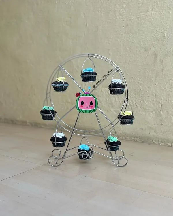 A fun way to display cupcakes at a Cocomelon party is with this cupcake ferris wheel.