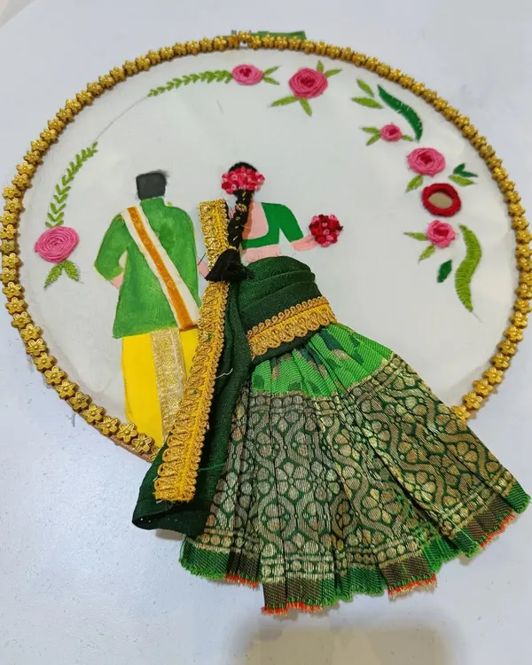 A beautiful hoop embroidery depicting a South Indian couple in traditional wedding attire. The bride's saree is made from real fabric, giving the piece a wonderful 3D effect.