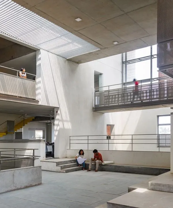 The central spine of the VIT School of Architecture, designed as a multi-level interactive zone. The visual connectivity between floors, with students visible on walkways and in breakout spaces, fosters a dynamic learning environment.