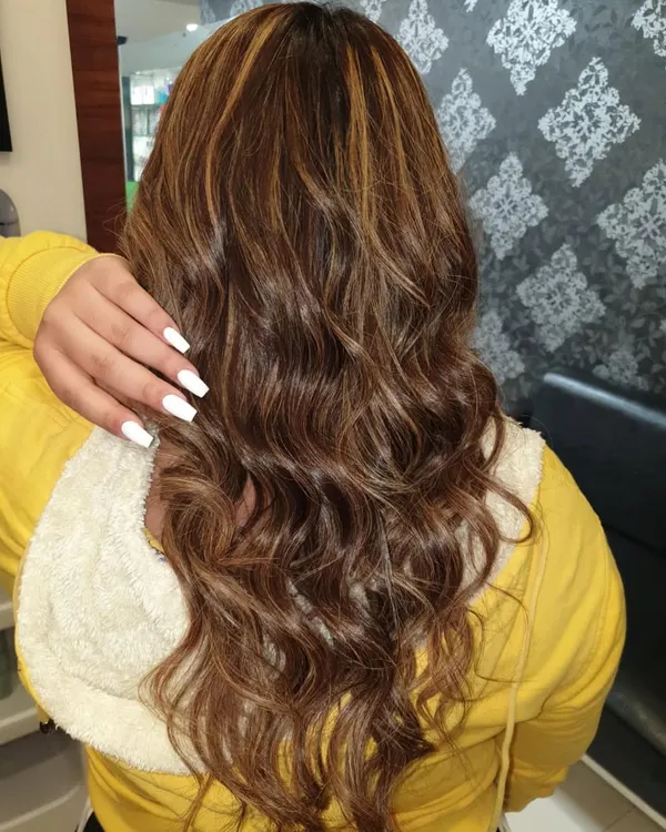 This client received a full head of highlights to add brightness and dimension to her long hair. The final look is styled into soft waves to showcase the blend of colors and the hair's healthy condition.