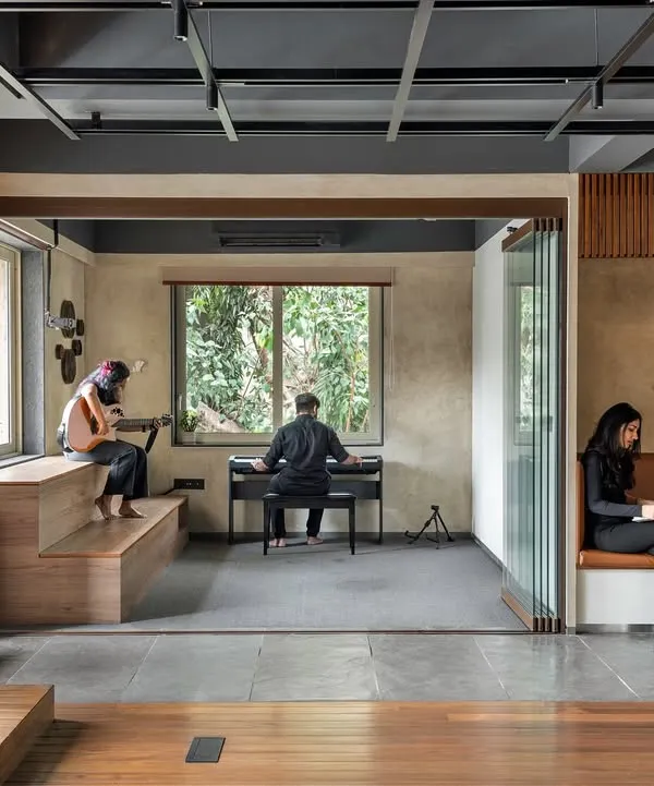 We designed this creative incubator to be a fluid environment that fosters both collaboration and individual focus. This view shows how different activities can coexist harmoniously, with a dedicated music and recording area flowing into a quiet reading nook, embodying our principle of creating multi-zonal, interconnected spaces.
