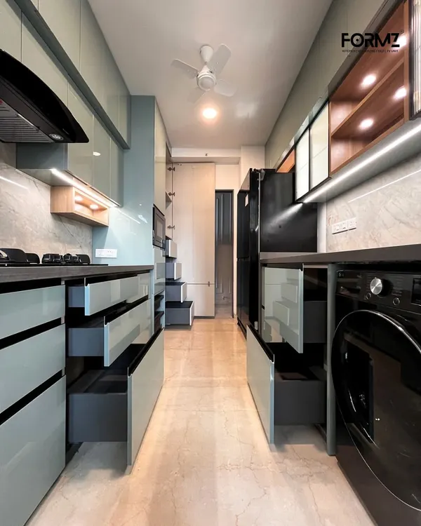 This galley kitchen is designed for maximum storage. On both sides, deep drawers and integrated units house everything from appliances to groceries, demonstrating how we optimize long, narrow spaces for complete functionality.