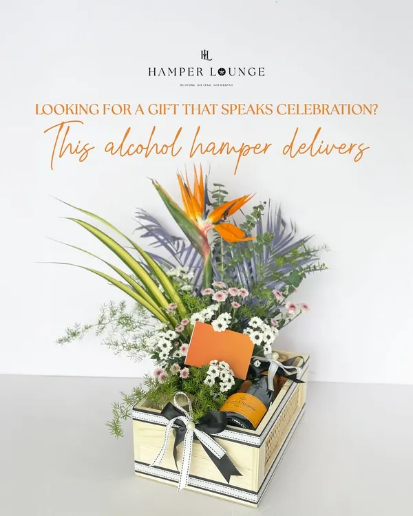 Looking for a gift that speaks celebration? This alcohol hamper delivers. It features a bottle of Veuve Clicquot champagne nestled in a stunning arrangement of tropical flowers and presented in a chic wooden crate.