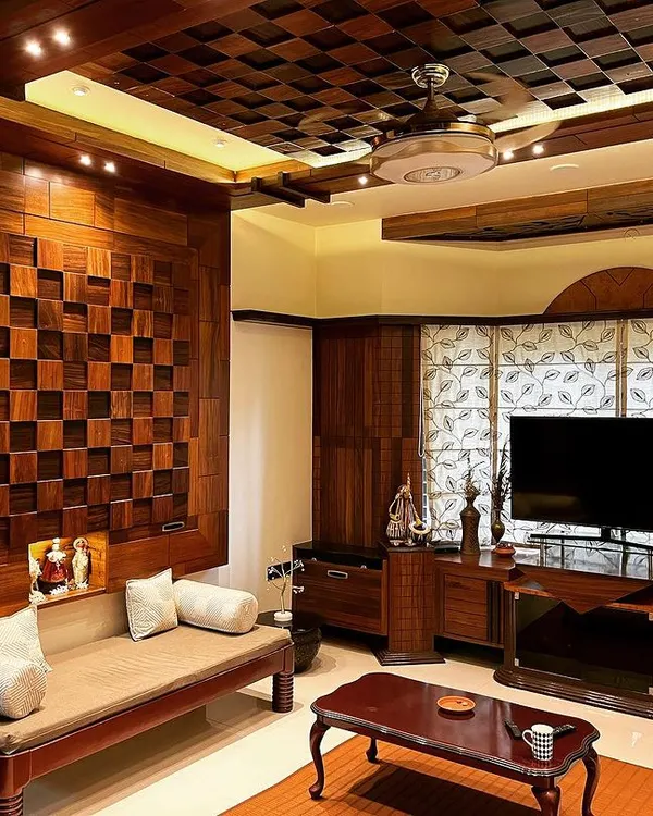 This living room in Hubli is designed for warmth and richness, using extensive wood paneling. The coffered ceiling and the checkerboard-patterned feature wall create a classic, sophisticated space for relaxation and entertainment.