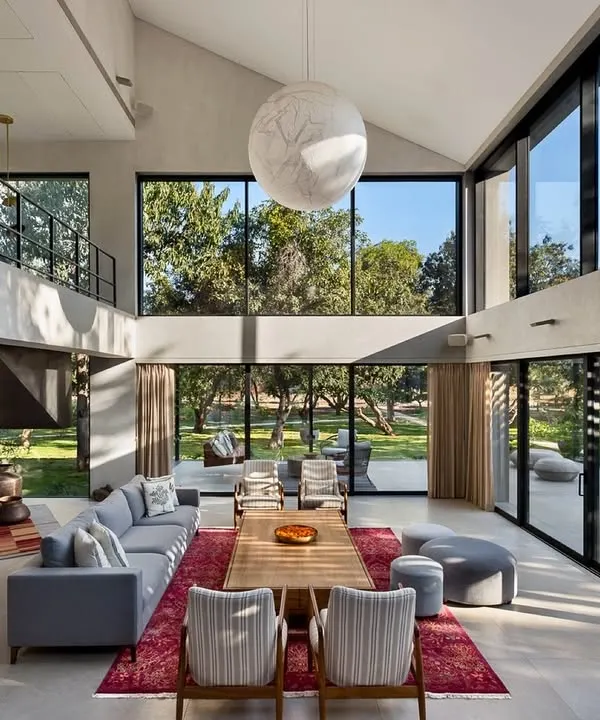 We believe a home's soul is its connection to the world outside. This double-height living room in our Mango Orchard House uses vast glass walls to dissolve the barrier between the interior and the surrounding landscape, creating a space that feels both grand and intimately connected to nature.