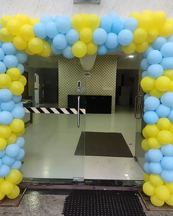 A classic balloon arch in bright yellow and light blue. This type of entrance decor is versatile and can be used for office openings, welcome events, or any cheerful celebration.