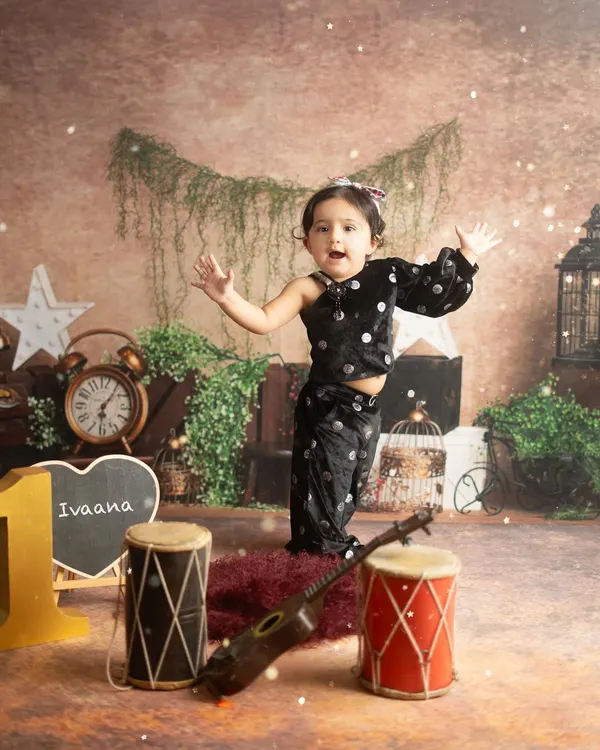 Little Ivaana celebrating her first birthday. This setup, with musical instruments and rustic decor, was designed to match her fun and energetic personality.