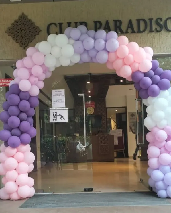 A beautiful pastel balloon arch welcomes guests to Club Paradiso for a butterfly-themed event. The blend of purple, pink, and white balloons creates a soft and dreamy entrance for a magical celebration.