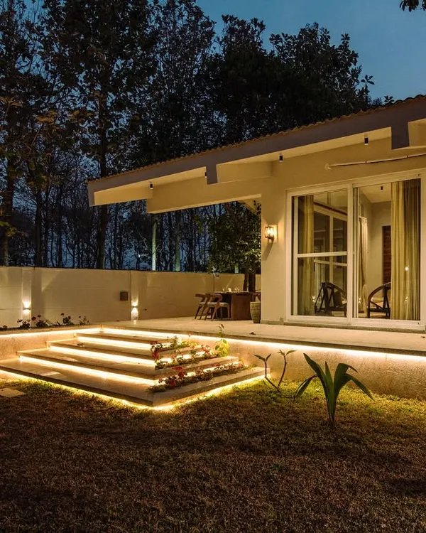 A beautiful night shot of the Amberle farmhouse. The landscape lighting is carefully placed to highlight the architecture and key landscape features without overwhelming the natural, starry sky.