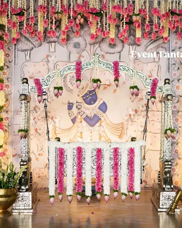For Dhanvith's naming ceremony, I designed this grand, traditional stage. The setup features a custom Pichwai-style backdrop of Lord Krishna, a decorated cradle, and authentic brass elements to create a truly sacred and memorable atmosphere for the family.