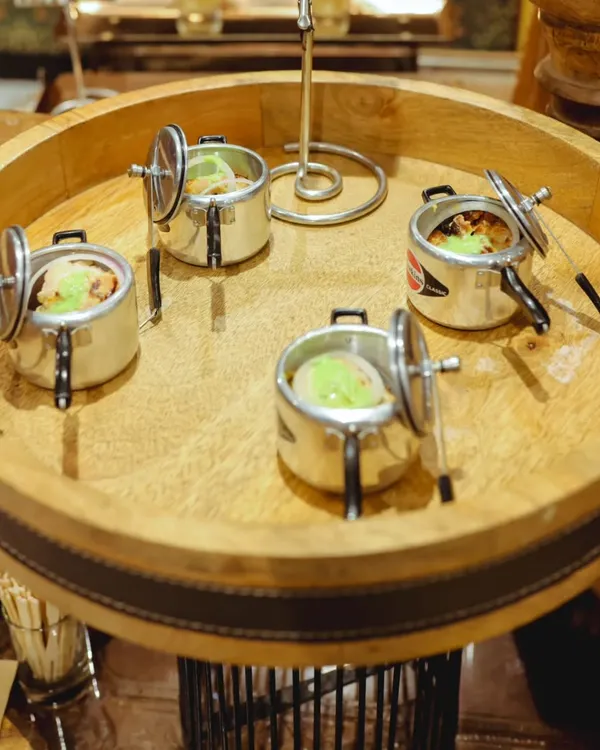 My signature mini pressure cookers used for serving individual portions of Indian dishes. This unique presentation adds a quirky and memorable touch to the dining experience.