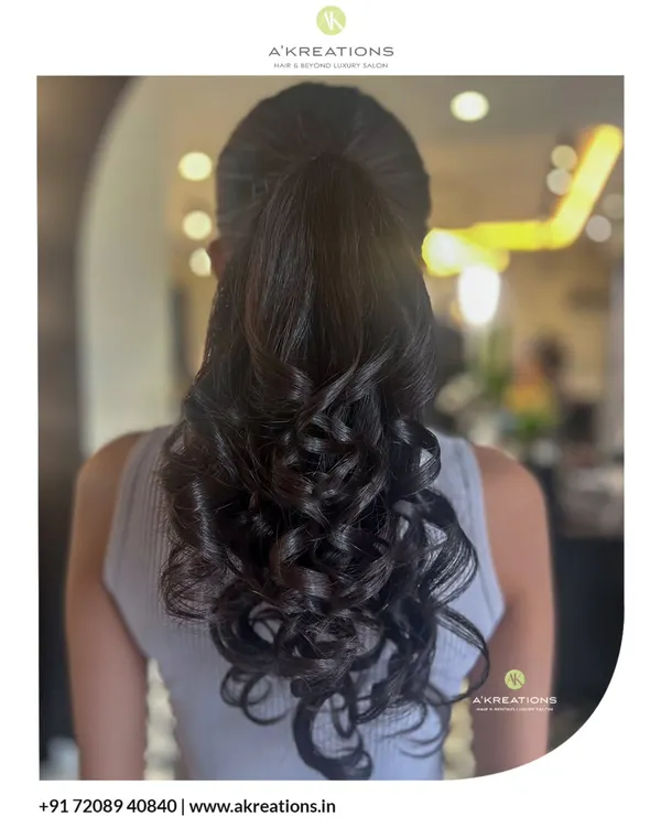 A classic high ponytail elevated with bouncy, perfectly formed curls. This hairstyle is both glamorous and practical for a long night of celebration.