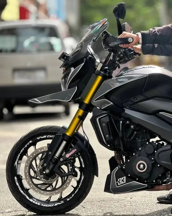 This Dominar got a full makeover with a Nardo Grey wrap. This close-up shows the custom paint job and details like the gold forks and wheel stickers.