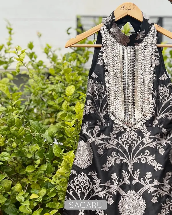 A statement halter-neck top crafted from black and silver brocade. The focal point is the heavily hand-embroidered yoke, which adds a touch of glamour, making it a perfect piece for a sangeet or cocktail event.