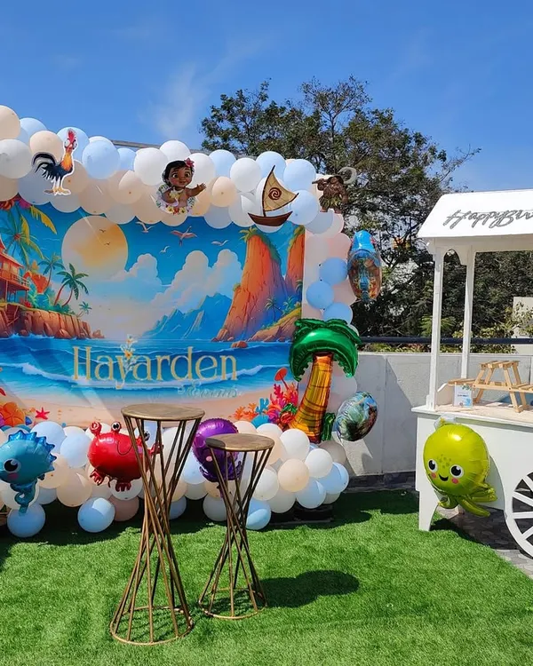 An outdoor Moana-themed party on a terrace with artificial grass. The setup is bright and perfect for a daytime celebration.