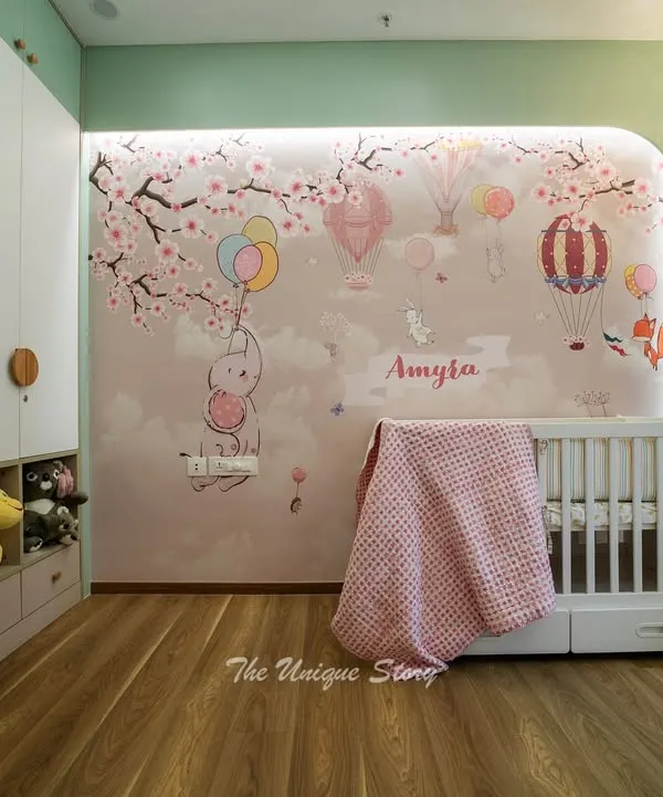A dreamy nursery for baby Amyra, featuring a custom wall mural of bunnies and hot air balloons. We designed a floor-to-ceiling wardrobe with integrated open cubbies for easy access to toys, combining whimsical design with practical storage.