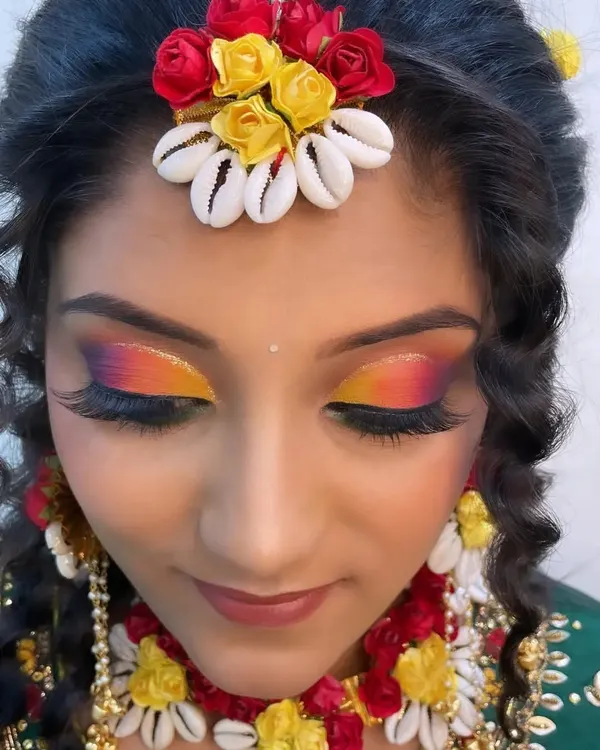A close-up of a vibrant Haldi eye makeup look, featuring a sunset-inspired blend of yellow, orange, and pink. This is perfect for the colorful and joyous Haldi ceremony.