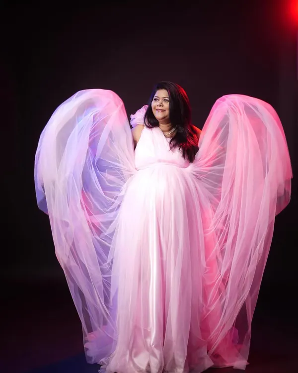 This is the ultimate glam shot. I use dramatic lighting and the flowing fabric of this pink rental gown to create a breathtaking, angelic portrait for expecting mothers.