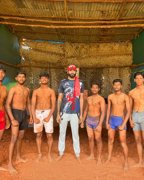 I stand with my students in our Garadi, the traditional mud pit for Kusti. This is where we build fighters from the ground up, connected to our Indian roots.