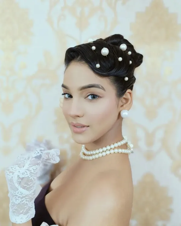 A close-up of my work for a "Vintage Revival" editorial. I created a classic 1920s inspired finger wave at the front, leading into a sleek bun, and scattered pearls throughout for an authentic, glamorous finish.