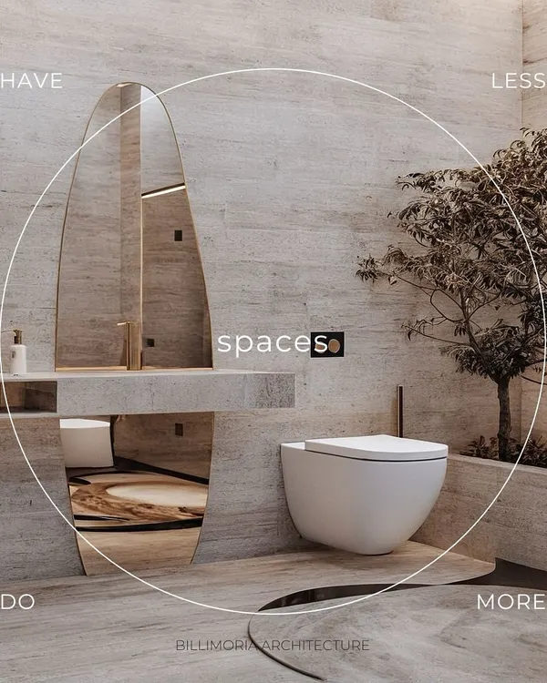 This minimalist bathroom is a study in tranquility, using floor-to-ceiling travertine stone. An organically shaped mirror and a small indoor tree bring natural elements into the space, creating a spa-like feel.
