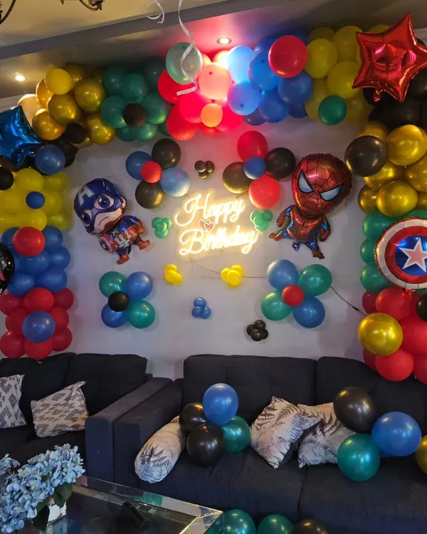 A close-up of our Marvel superhero balloon arch, featuring Captain America and Spider-Man foil balloons, a 'Happy Birthday' neon sign, and a vibrant color scheme.