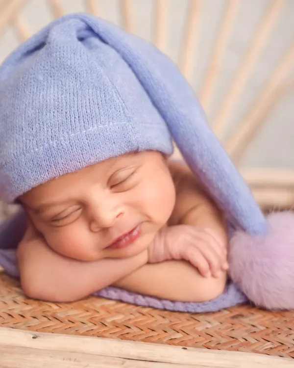 This little smile is everything. We specialize in capturing these fleeting, peaceful moments with newborns, using soft wraps and gentle posing to keep them comfortable and sleepy.