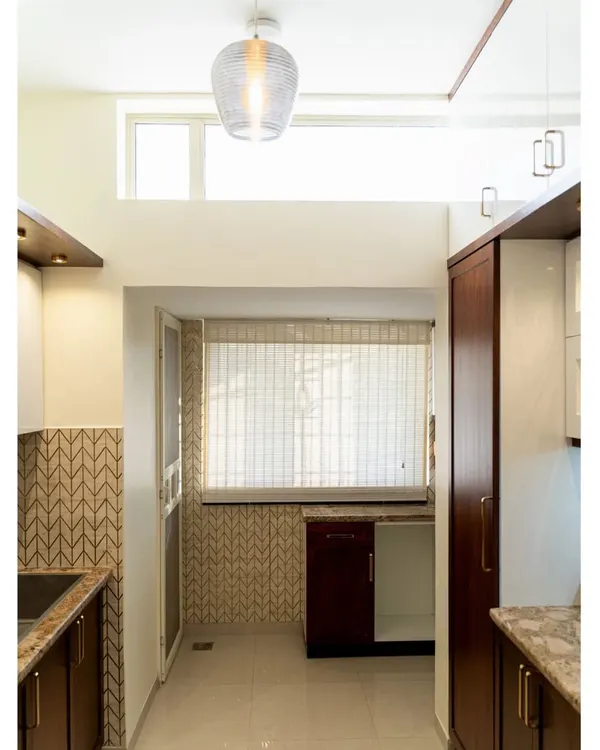 We transformed this kitchen by removing a wall to create a brighter, more open space. The design features a mix of dark wood and white cabinets, a unique brown granite countertop, and a beautiful glass tile backsplash that comes to life in the daylight.