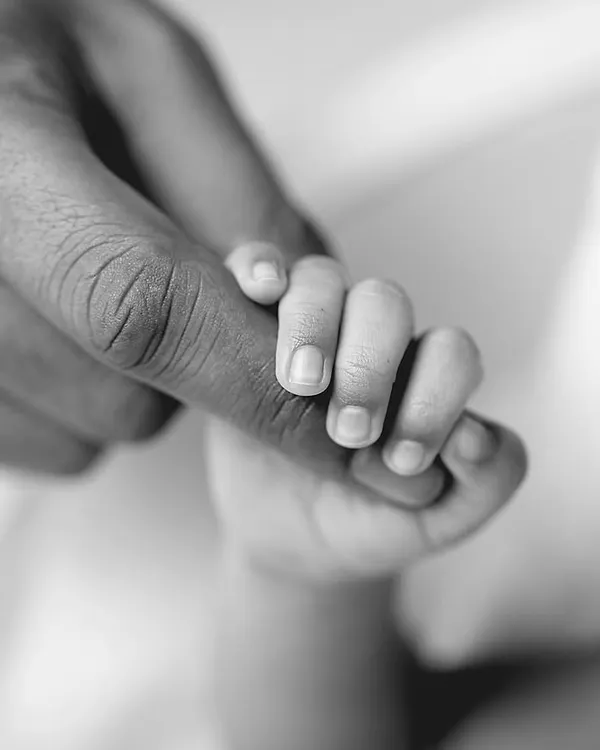 A newborn's hand instinctively curling around a parent's finger is a powerful symbol of trust, safety, and the beginning of an unbreakable bond.