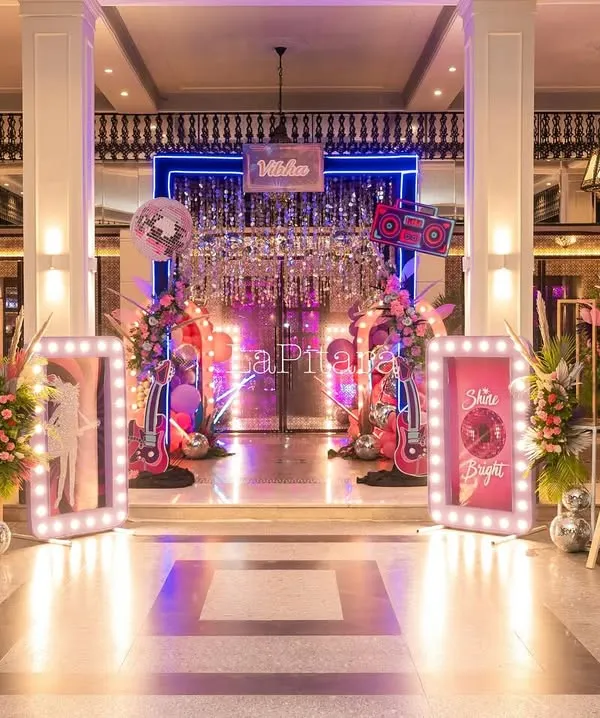The grand entrance to an 11th birthday disco extravaganza, featuring a shimmering curtain, neon signs, and illuminated frames that set a glamorous and funky tone.