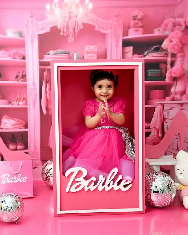 Come on Barbie, let's go party! This little doll is celebrating her first birthday in her very own life-sized Barbie box, surrounded by all things pink and sparkly. This is a perfect example of a high-concept birthday theme shoot that brings a childhood dream to life.