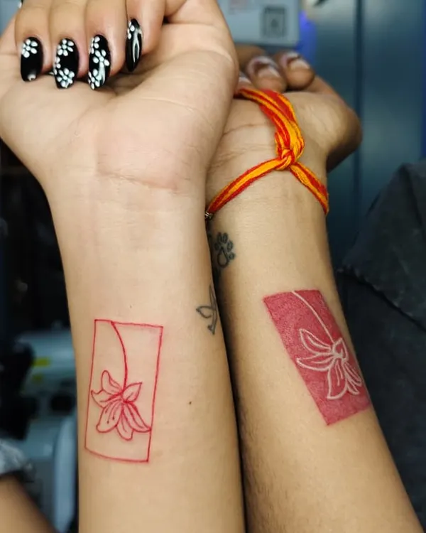 When love is permanent, so is the ink. These matching red ink floral tattoos are a beautiful and artistic way for a couple to show their connection.