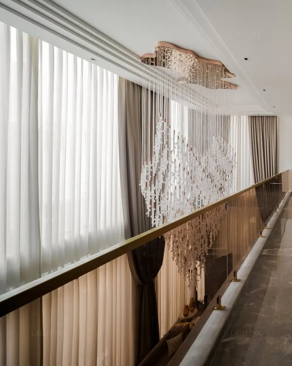 What brings life to a double-height home? This cascading chandelier transforms the volume into an experience of light and movement. Suspended delicately, it becomes the heart of the home, a piece you don’t just look at, but feel.