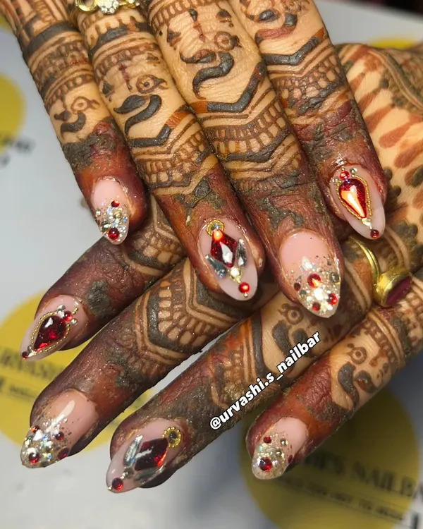 This is where art meets tradition. I designed this custom bridal set with ruby-red and silver gems to perfectly complement the beautiful, deep tones of the mehendi. It's all about creating a look that feels both royal and personal for your special day.