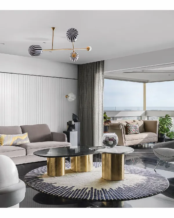 This is the story of a home where the sea is a constant guest. We designed this sprawling living room in Mumbai to be a calm escape from the city's chaos, with sprawling views of the horizon. The space is a careful composition of custom furniture, a sunburst rug, and a palette that echoes the changing colors of the sky and water, creating a perfect seaside apartment experience.