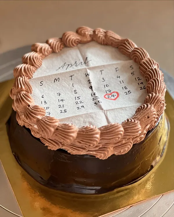This is a "burn away" cake, one of our best sellers. This design features a calendar marking a special date, and the top layer burns away to reveal a hidden message or image underneath.