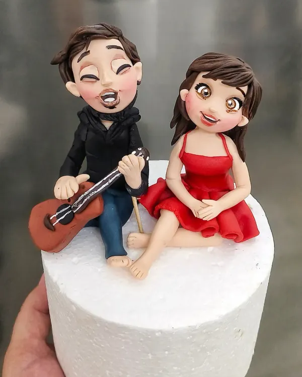 This custom cake topper tells a love story. He plays the guitar, and she listens. I love creating these personalized figurines that capture the unique connection between two people, making their celebration cake truly one of a kind.