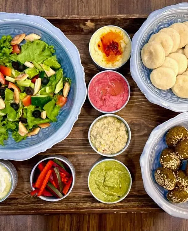 This is my most popular Mezze Platter, and you can see why! It's a full spread with classic hummus, beetroot hummus, pesto hummus, baba ghanoush, falafel, labneh, fattoush salad, pickles, and mini pita breads.