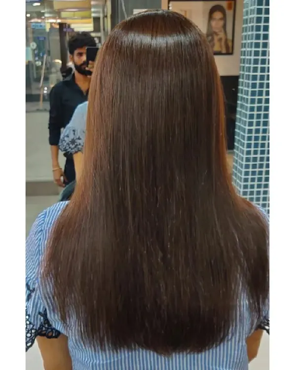 A perfect example of a flawless global hair color application. The result is this incredibly shiny, healthy-looking, and uniform shade of medium brown on long, straight hair.