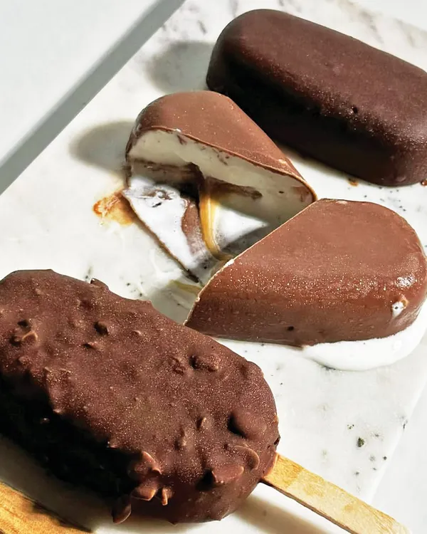 Beat the heat with our artisanal ice cream bars, made with the finest ingredients. This selection shows our classic chocolate, almond-coated, and caramel-filled bars.