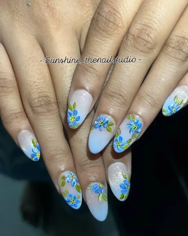 A beautiful example of hand-painted floral art. This spring-themed set features delicate blue flowers on a light blue ombre base with a touch of glitter.