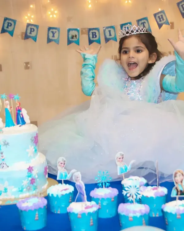 The birthday girl's priceless reaction at her Frozen-themed party. I love capturing the excitement around the cake and decorations.