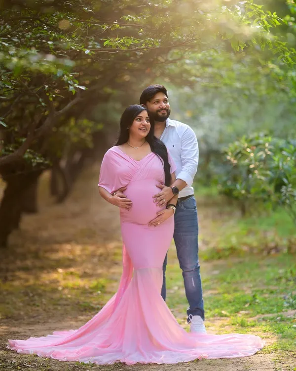 A classic portrait from an outdoor maternity session. The flowing gown and the beautiful golden light filtering through the trees create a truly magical and elegant look for this expecting couple.