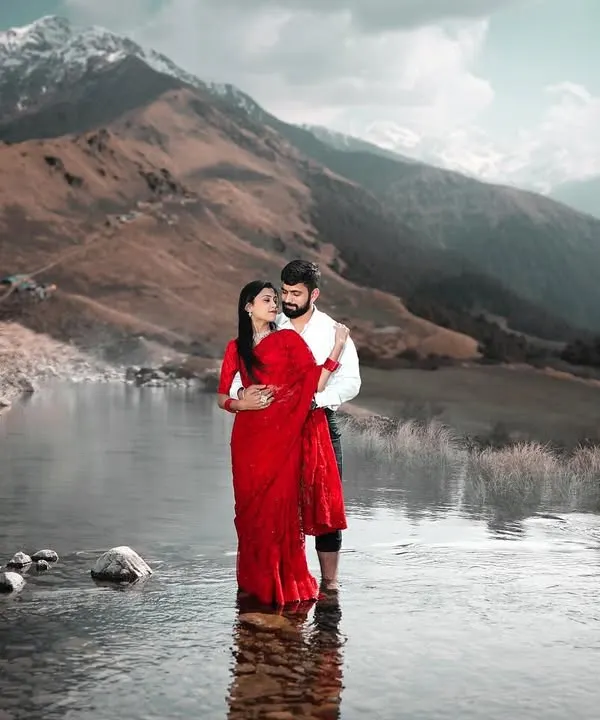 For couples who want their love story set against a truly epic backdrop, I find hidden gems like this serene mountain lake. The contrast of the vibrant red saree against the snow-dusted peaks and calm water creates a breathtaking, once-in-a-lifetime portrait.