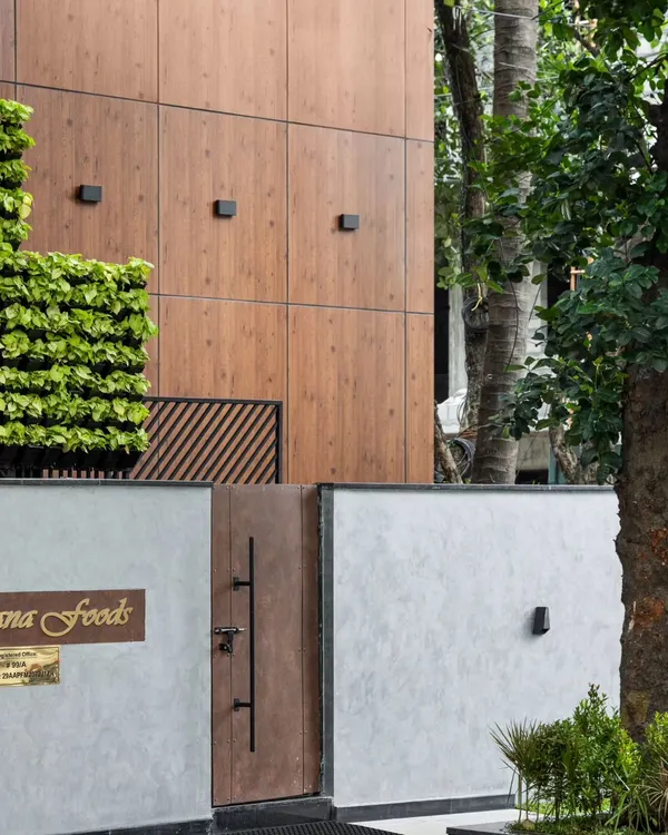 The entrance to the Meghana Foods Corporate office, nestled in a tree-lined avenue in Koramangala. The design features a modern facade with a vertical garden, creating an inviting yet professional statement that stands out in a busy commercial hub.