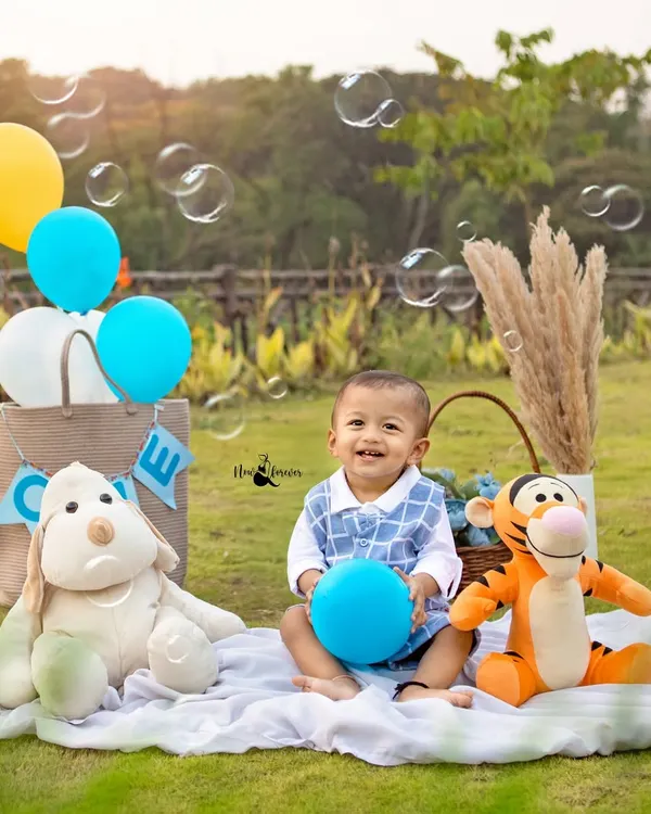 Pure happiness. This little boy's smile is infectious as he plays with bubbles during his outdoor picnic themed first birthday shoot.